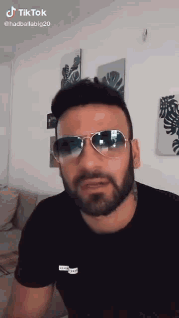 a man with a beard wearing sunglasses and a black t-shirt
