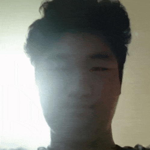 a man with his eyes closed looks at the camera