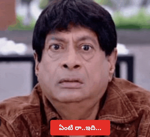 a close up of a man 's face with a red sticker that says ' telugu ' on the bottom
