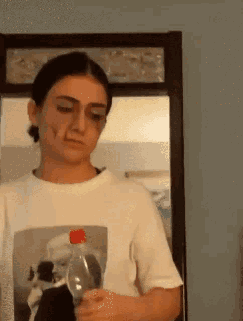 a woman with a black eye is holding a bottle of soda