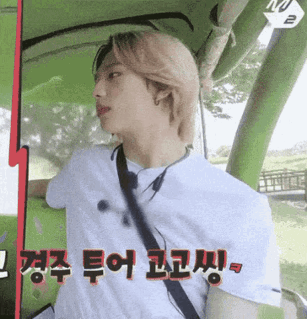 a man in a white shirt and tie is sitting in a car with korean writing on the side