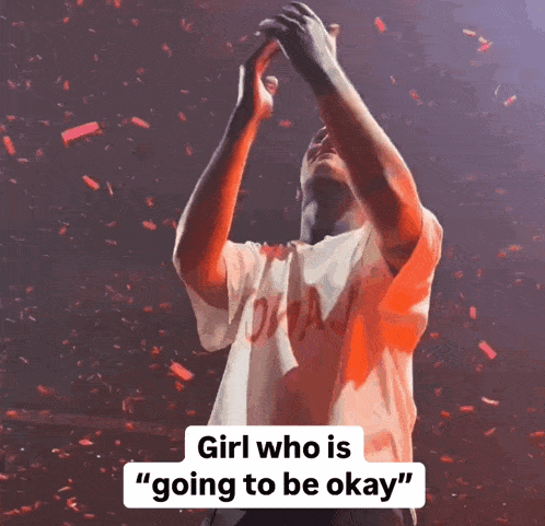 a man in a white shirt with the word drake on it holds his hands in the air