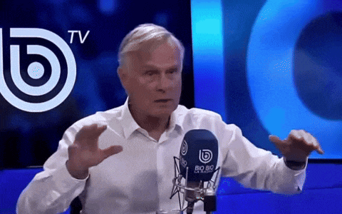 a man talking into a microphone with a big 80 logo behind him