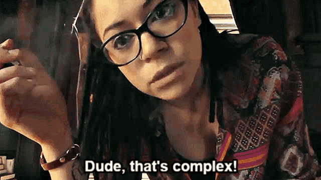 a woman with glasses and dreadlocks is smoking a cigarette and says dude that 's complex