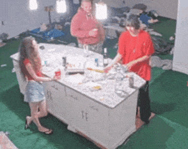 a group of people are standing around a kitchen counter