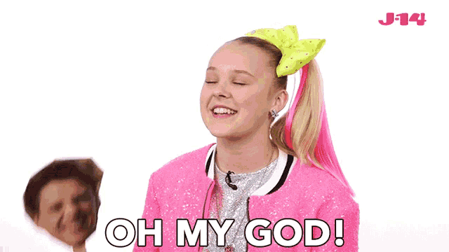 a girl with pink hair and a bow in her hair is saying oh my god .