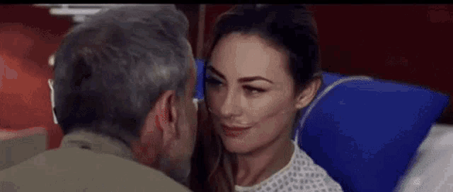 a man and a woman are sitting next to each other in a hospital bed .