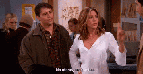 a man and a woman are standing next to each other in a room and the woman is talking about uterus .