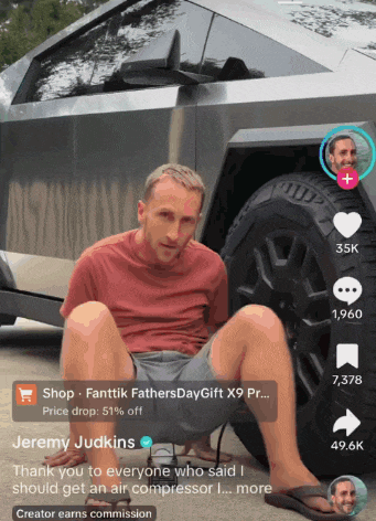 jeremy judkins is sitting on the ground in front of a car with his feet up
