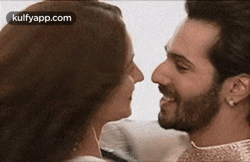a man and a woman are looking at each other and kissing .