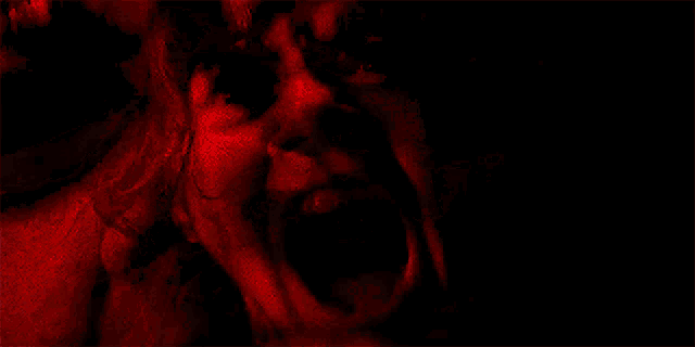 a dark cave with a red light shining through the walls