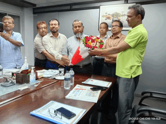 a man holds a bouquet of flowers in front of a group of men