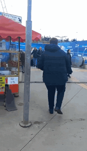 a man is walking past a sign that says su 5tl