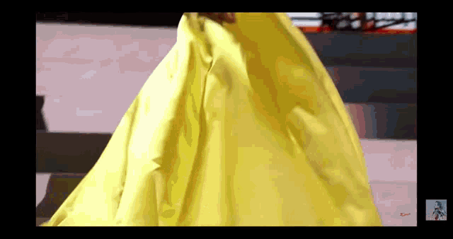 a woman in a long yellow dress is walking down a runway