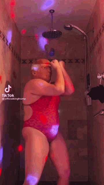 a woman in a bathing suit with a trump mask on is dancing in a shower