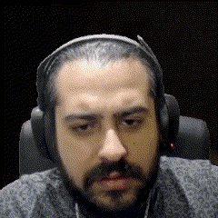 a man with a beard wearing headphones and a gray shirt