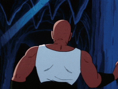 a man in a white tank top stands in a dark room