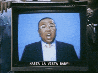 a man in a suit is on a television screen with the words hasta la vista baby on it