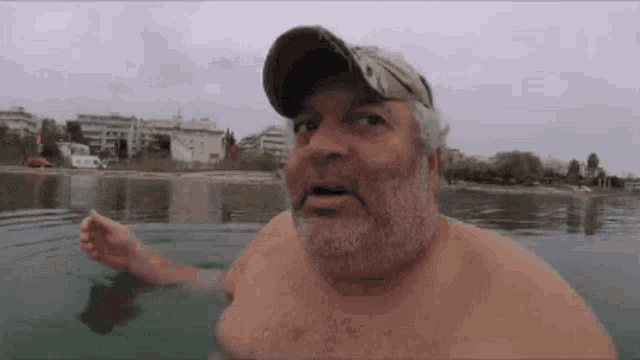 a man with a beard is swimming in a lake