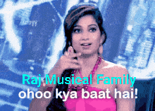 a woman in a pink dress is pointing at something with the words raj musical family ohoo kya baat hai