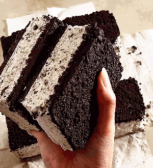 a person is holding a slice of oreo ice cream cake