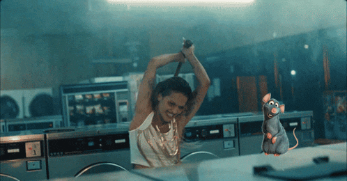 a woman is holding a knife in a laundromat while a cartoon rat is hanging from the ceiling