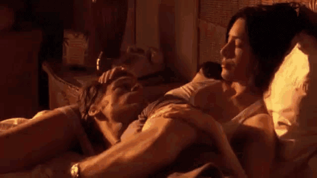 a man and a woman are laying in a bed .
