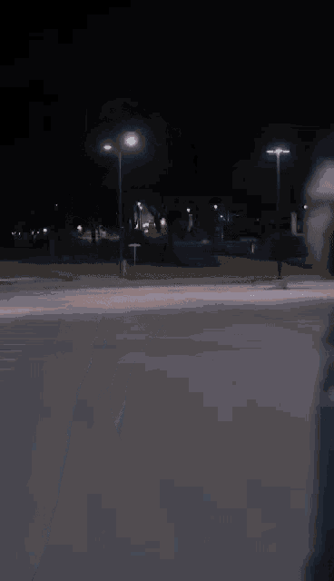 a person walking down a street at night