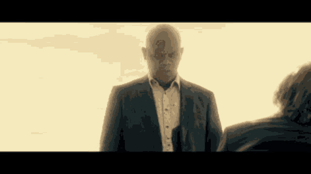 a man in a suit and tie is standing next to another man in a suit and tie .