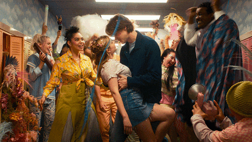 a group of people are dancing in a hallway including a man and a woman