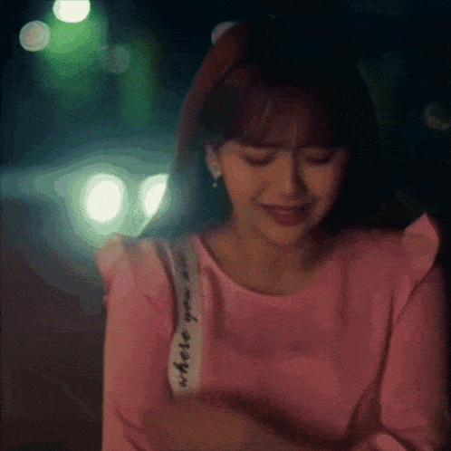 a woman wearing a pink shirt with a white strap that says where you are