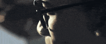 a close up of a person wearing a gold necklace with a coin on it