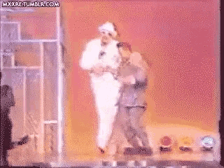 a pixelated image of two men dancing on a stage with the website mxxxre.tumblr.com in the lower right corner