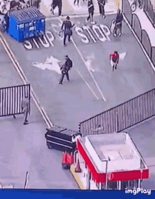 a group of people walking down a street with a sign that says stop