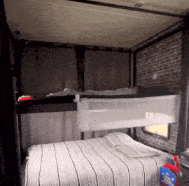 a bed with a striped blanket and a laundry detergent bottle