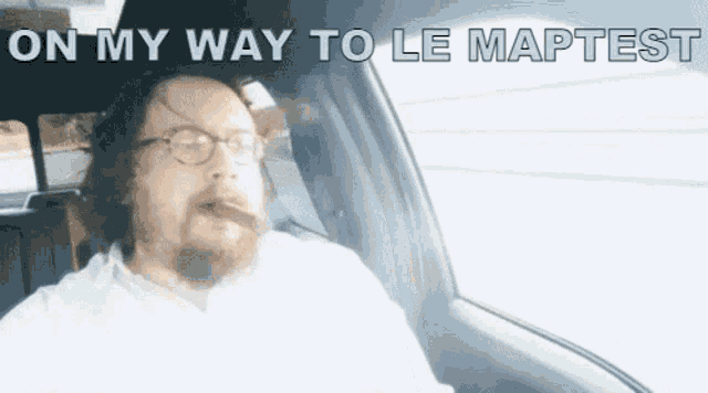 a man smoking a cigar in a car with on my way to le maptest written above him