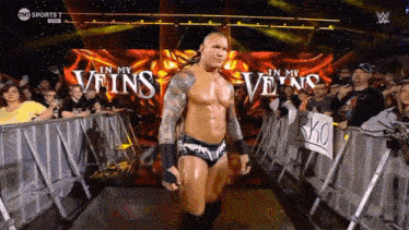a man in a wrestling ring with the words " in my veins " behind him