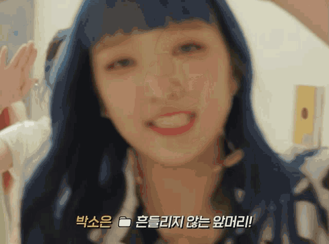 a close up of a woman with blue hair and asian writing on her face