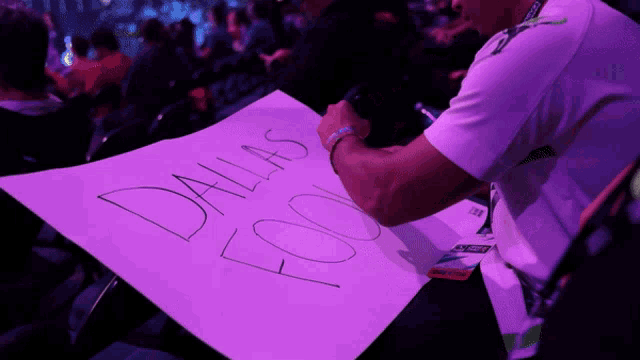 a person holding a sign that says dallas fools