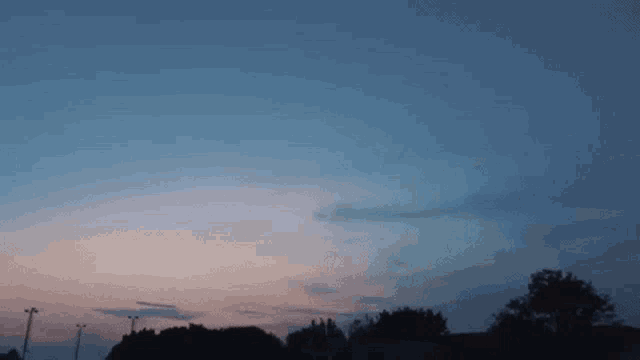 a sunset with a few trees in the foreground
