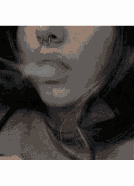 a close up of a woman 's face with a nose piercing