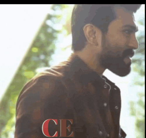 a man with a beard is standing in front of a sign that says ce on it