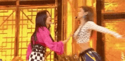 two women are dancing together on a stage .