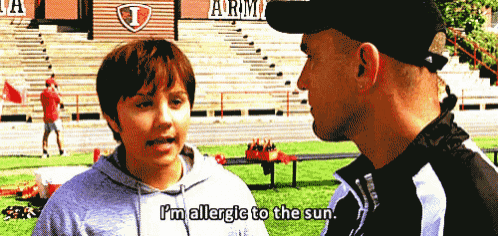 a boy talking to a man with the words i 'm allergic to the sun on his shirt