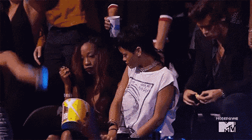 a group of people are sitting in a stadium and one of them is eating popcorn