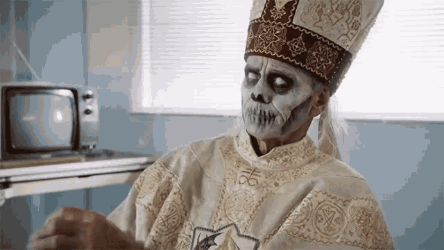 a man with a skeleton face painted on his face is wearing a white robe