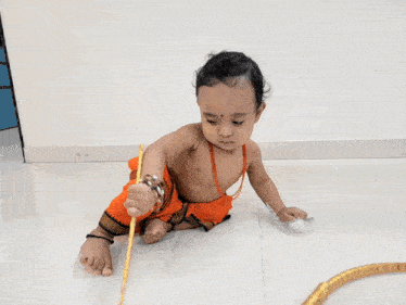 a baby with a red dot on his forehead is playing with a drum