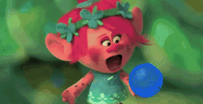 a troll from the movie trolls is standing in a pile of plants .