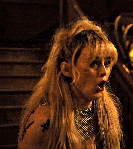 a woman with blonde hair and a tattoo on her shoulder