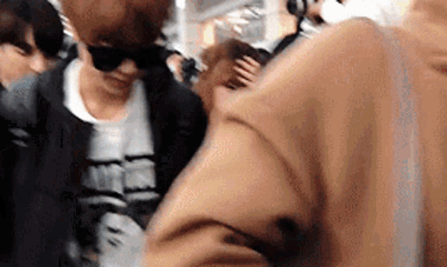 a blurry picture of a man wearing sunglasses and a white shirt .